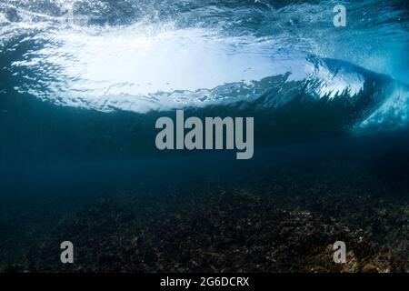 Underwater view of rough rocky bottom of sea with blue water at daytime ...