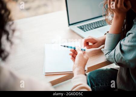 Coworkers brainstorming ideas with laptop, notepad and pen. Woman and man discussing a company plan for future, organization finances and development Stock Photo