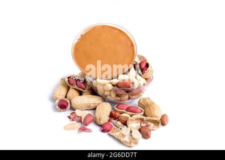 Peanut butter isolated and peanuts in the peel scattered on the white background. Copy space Stock Photo