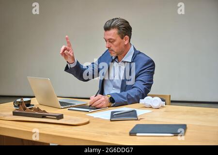 Designer at his desk working on his computer using his tablet Stock Photo