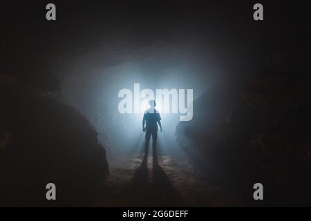 Male explorer standing at cave entrance Stock Photo - Alamy