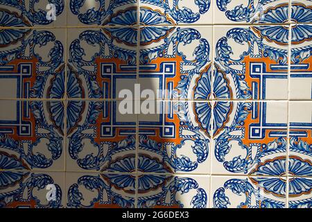 Traditional portugal tiles in blue and orange on white azulejo. Close up of colorful portuguese art and architecture symbol with natural light Stock Photo