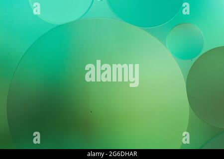 Green-colored bubbles formed by oil in water. Stock Photo