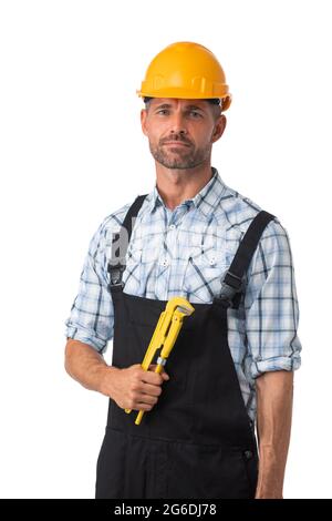 Portrait of confident male repairman contractor worker in coveralls holding adjustable spanner isolated on white background Stock Photo