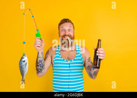 man with beard and swimsuit caught a fish Stock Photo