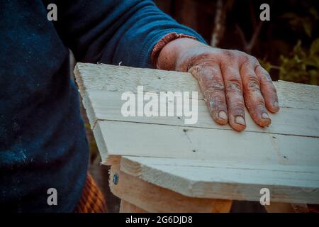 Close up of an old woman hands craftworking on wood Stock Photo