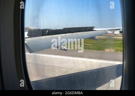 An airplane window view of wing and flaps after landing. Landing ...