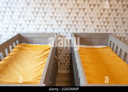 A Twin Bedroom with wooden baby beds for siblings, newborn babies modern stylish interior Stock Photo