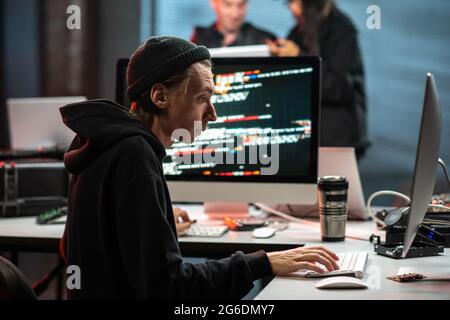 Busy young man using two computers simultaneously Stock Photo