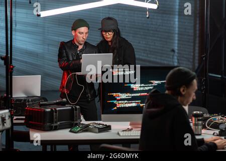 Two young programmers or hackers using laptop Stock Photo