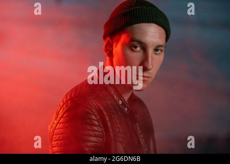 Young male hacker or terrorist in black jacket and cap Stock Photo