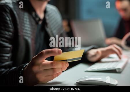 Hands of hacker with plastic card stealing personal information Stock Photo