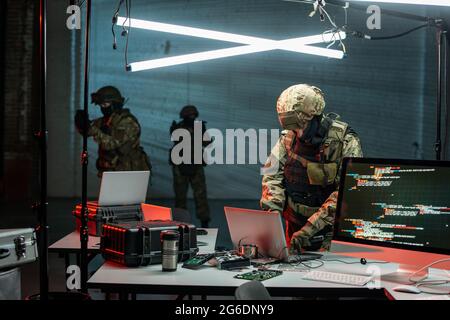 Crime fighters in uniform looking for information stealers in office Stock Photo