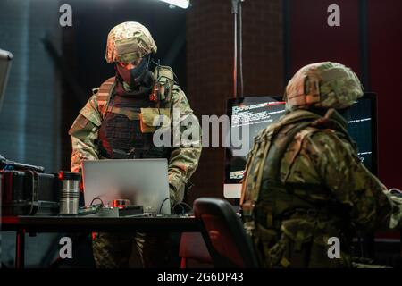 Network criminals in camouflage attire stealing secret information Stock Photo