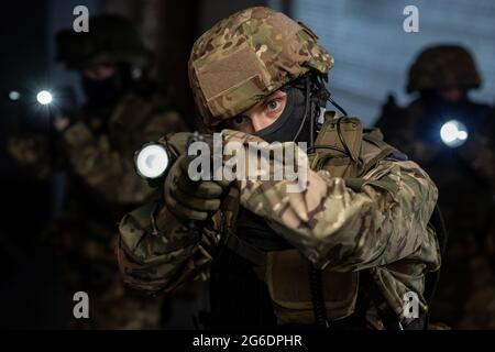 Group of criminals with lanterns and guns in dark room Stock Photo