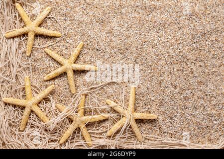 starfish and fishing net border in the sand Stock Photo