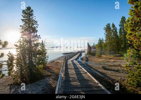 Boardwalk on the shore of the West Thumb of Yellowstone Lake, morning sun, West Thumb Geyser Basin, Yellowstone National Park, Wyoming, USA Stock Photo