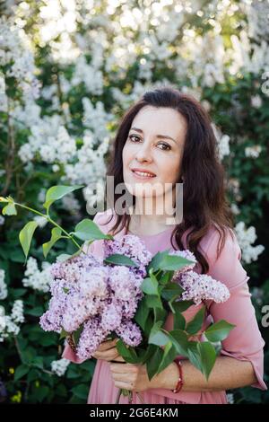 portrait of a beautiful woman in a lilac dress with lilac flowers Stock Photo