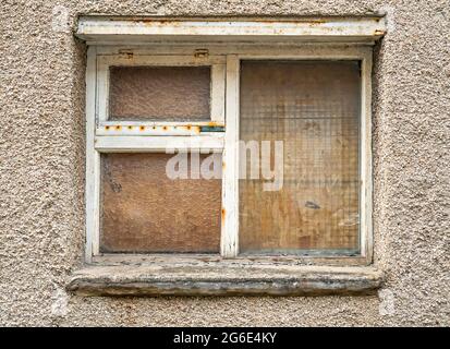 Boarded up window of building in town back street Stock Photo