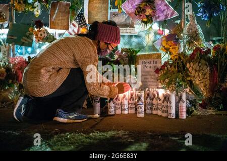 Boulder, Colorado, USA. 22nd Mar, 2021. A woman adds flowers to a memorial made on fence surrounding the King Soopers where a mass shooting took the live of ten people in Boulder, Colorado. Credit: Carl Payne/ZUMA Wire/ZUMAPRESS.com/Alamy Live News Stock Photo