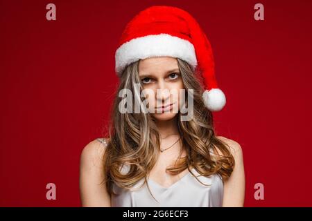 Upset attractive lady in dress wearing Santa hat Stock Photo