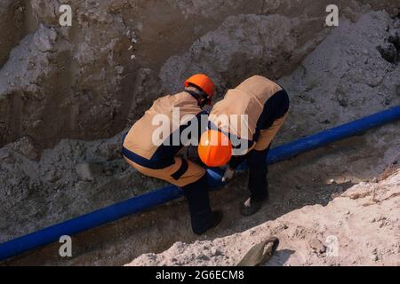 Workers are installing water supply pipeline system. Stock Photo
