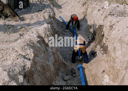 Workers are installing water supply pipeline system. Stock Photo