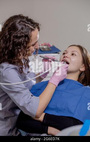 Professional doctor dentist examine and treat spoiled teeth with the use of special dental instruments, medical equipments. Healthy teeth concept Stock Photo