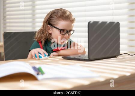 Schoolboy studying homework math during her online lesson at home ...