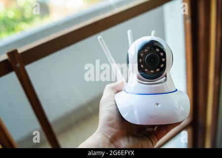 Close up on hand of unknown man holding home security surveillance camera Stock Photo