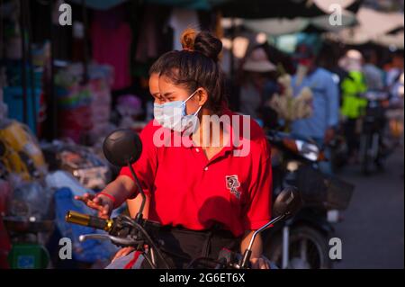 Cambodian twins wearing protective face masks / coverings & shopping on a motorcycle at Kandal Market during the coronavirus pandemic. Phnom Penh, Cambodia. March 31st, 2020. © Kraig Lieb Stock Photo