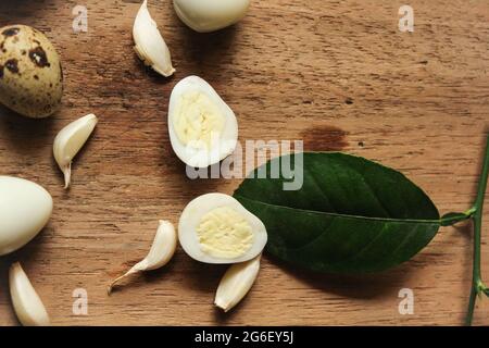 Sliced boiled quail eggs on wooden surface, top view Stock Photo
