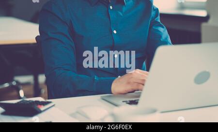 Cropped faceless man freelancer working on laptop computer remotely Stock Photo