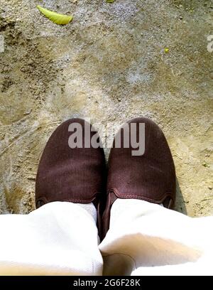 Top view of a pair of brown sneakers shoes on concrete floor background Stock Photo