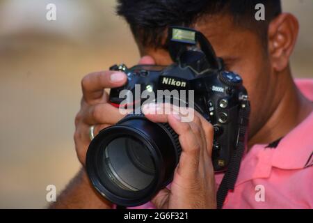 Indian Young Man using DSLR Camera Stock Photo