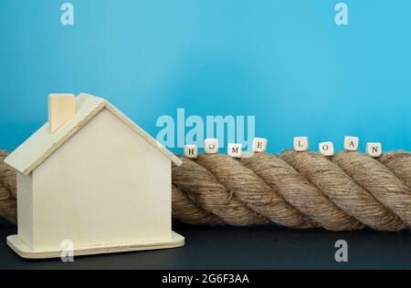 Financial concept. Rope, house model and wooden blocks with text. Selective focus points. Stock Photo