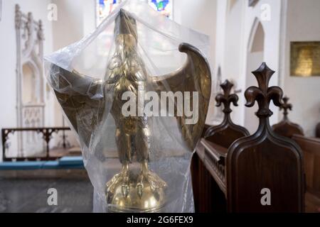 The lectern in the form of an eagle is covered by plastic between religious services in St Mary's, a rural English church in Baconsthorpe, on 28th June 2021, in Baconsthorpe, Norfolk, England. The eagle was believed to be the bird that flew highest in the sky and was therefore closest to heaven. Stock Photo