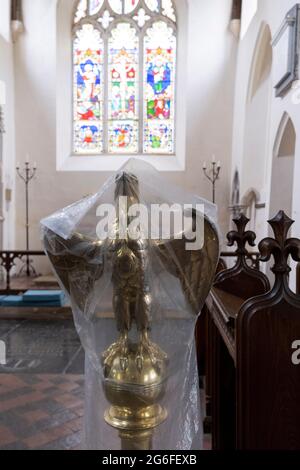 The lectern in the form of an eagle is covered by plastic between religious services in St Mary's, a rural English church in Baconsthorpe, on 28th June 2021, in Baconsthorpe, Norfolk, England. The eagle was believed to be the bird that flew highest in the sky and was therefore closest to heaven. Stock Photo