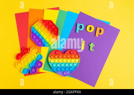 Pop it fidget sensory toy on a yellow background. Top view. Stock Photo