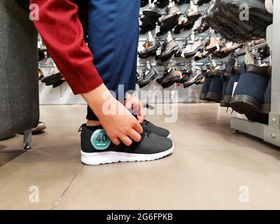 Wearing shoes. Buying shoes from the store. Stock Photo