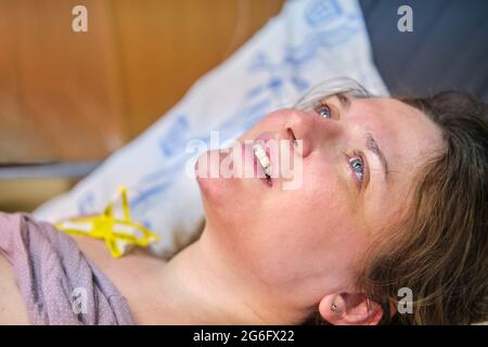 Portrait of a happy mother immediately after a successful birth on the bed in the maternity ward Stock Photo