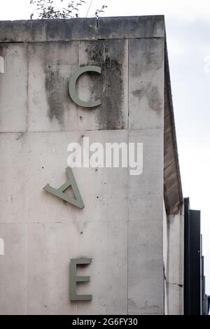 Letter A falling down hanging from side of derelict abandoned old 1970's concrete building. Sign dropping off wall.