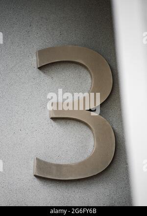 Number three text isolated 3D numeric 3 made from stainless steel chrome metal shiny and modern. Three dimensional symbol mounted on concrete pillar. Stock Photo