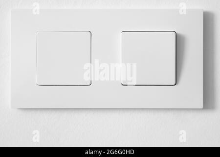 White light switch over a white textured wall. Home equipment Stock Photo