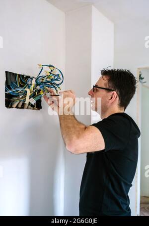 Electrician working on the electrical installation of a house Stock Photo