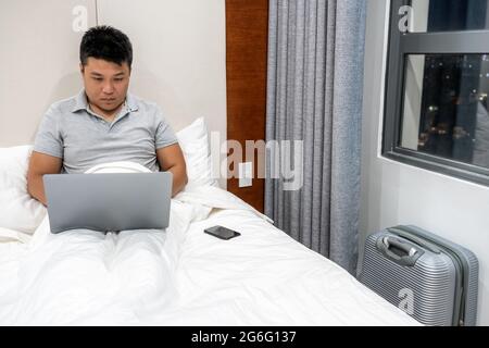 Asian businessman working late at hotel Stock Photo