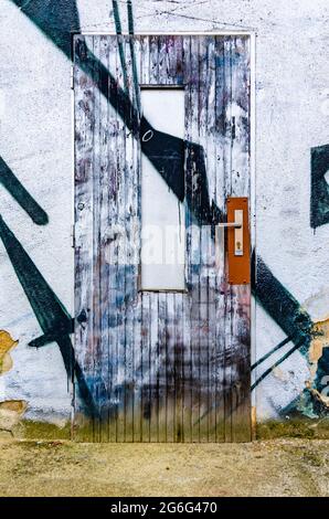 Painted old ugly door - graffiti on building exterior Stock Photo