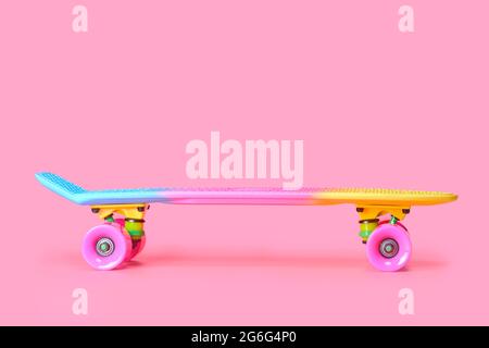 rainbow plastic Penny board skateboard isolated on pink background Stock Photo