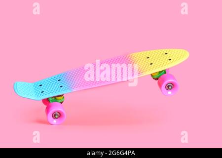 rainbow plastic Penny board skateboard isolated on pink background Stock Photo