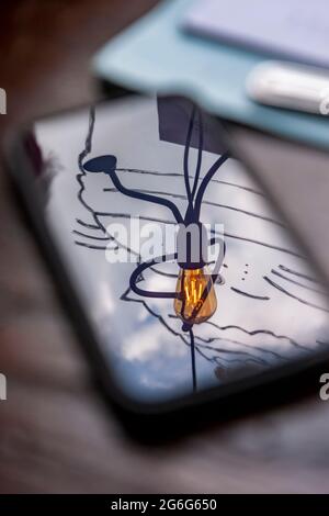 A light in a cafe window reflecting in a mobile phone laid on a table. Stock Photo